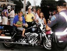 A child getting to sit on an officer's motorcycle